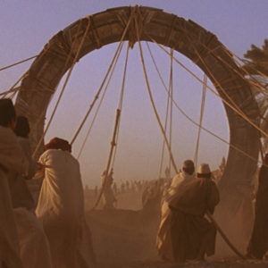 The front face of the stargate as it is lifted out of the pit it was buried in. Several symbols are visible, including the original symbol for Earth